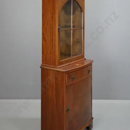 reproduction Victorian style walnut display cabinet with cupboard in base, swan neck pediment and arched glazed door,