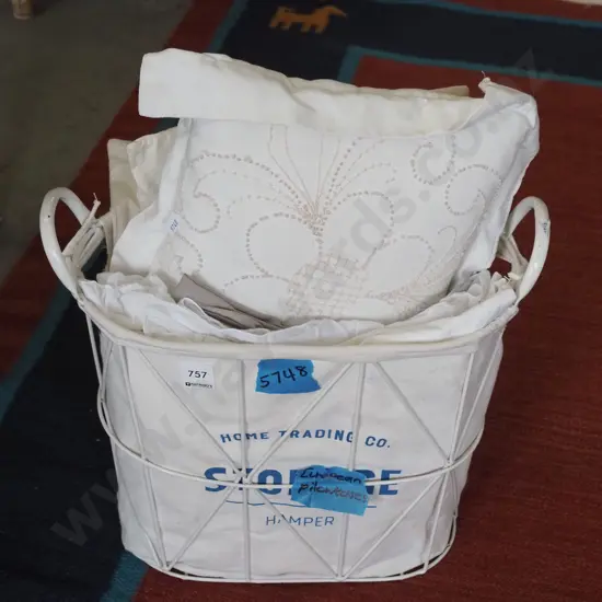 wire basket filled with European cushions and pillow cases