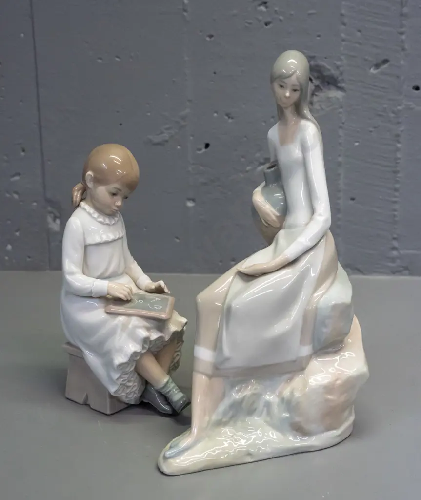 2 Nao figurines - seated woman with urn H-250 W-170 and seated girl with slate Image 1++