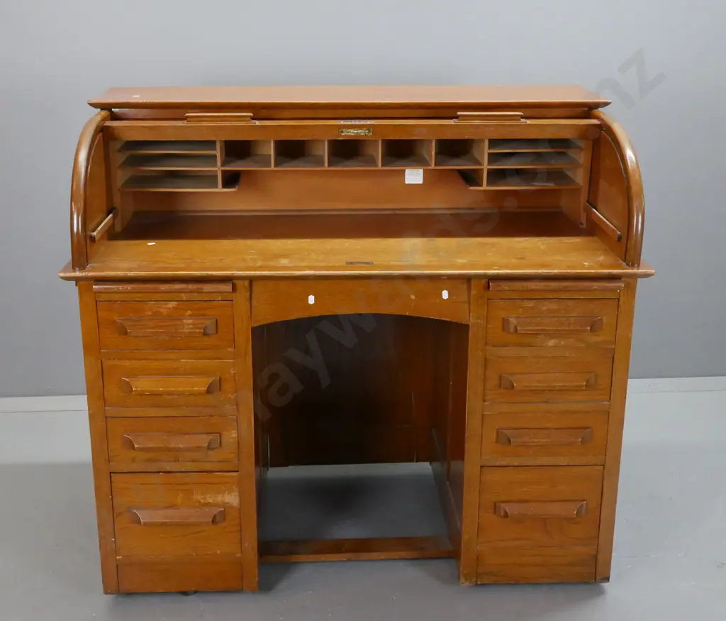 mid-century oak roll-top desk, tambour lid exposing pigeon holes above 2 pedestals w/ 8 drawers & 2 slides. Tambour top Image 1++