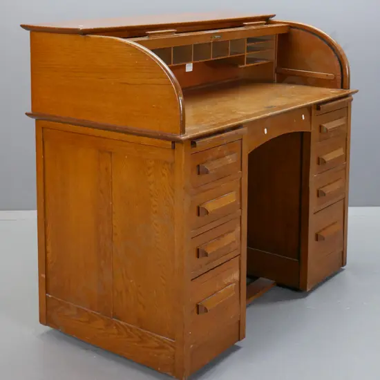 mid-century oak roll-top desk, tambour lid exposing pigeon holes above 2 pedestals w/ 8 drawers & 2 slides. Tambour top