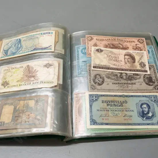 album full of assorted banknotes - a few NZ dollars, otherwise international
