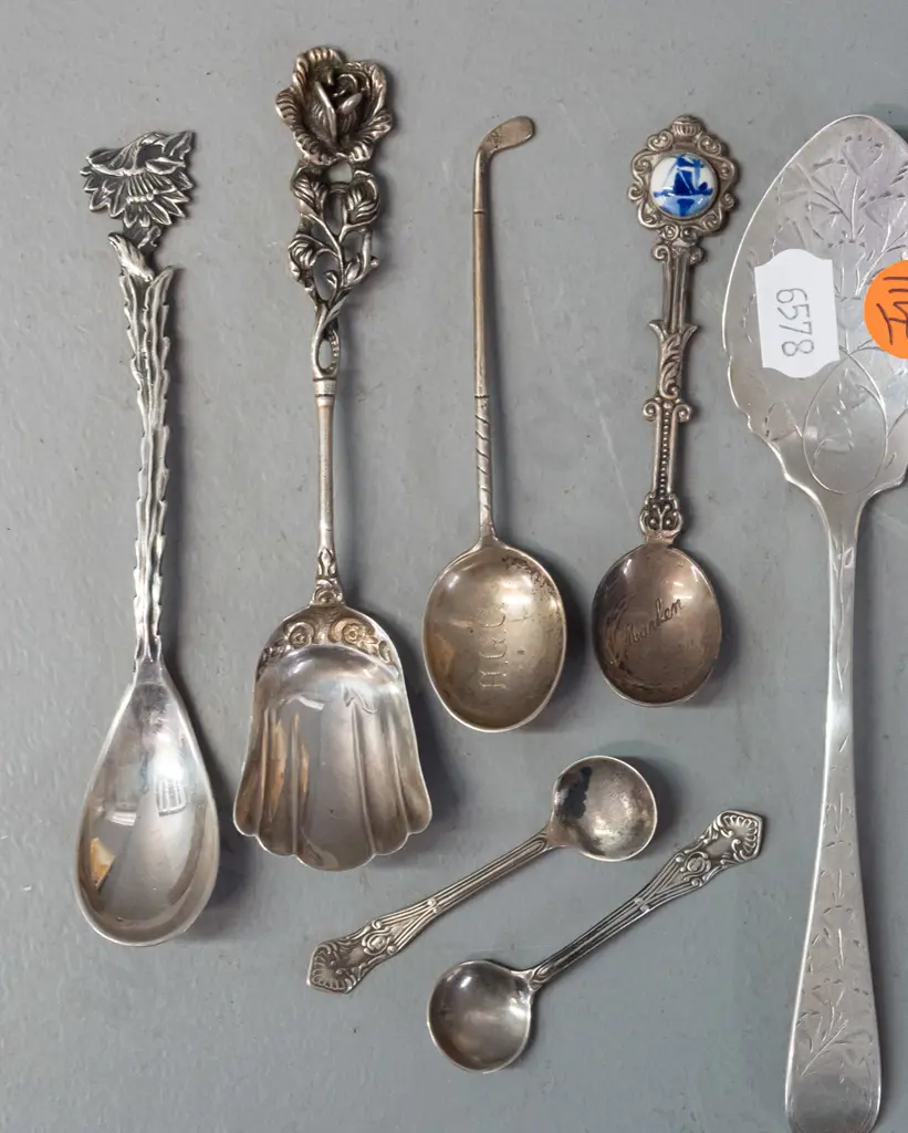 11 decorative and figural cutlery items, most hallmarked or marked sterling silver, one with porcelain ornament. Image 1++
