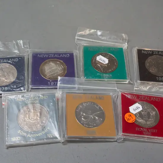 7 New Zealand commemorative dollar coins in plastic cases - 1975, 78, 80 81, 83, 85, 86