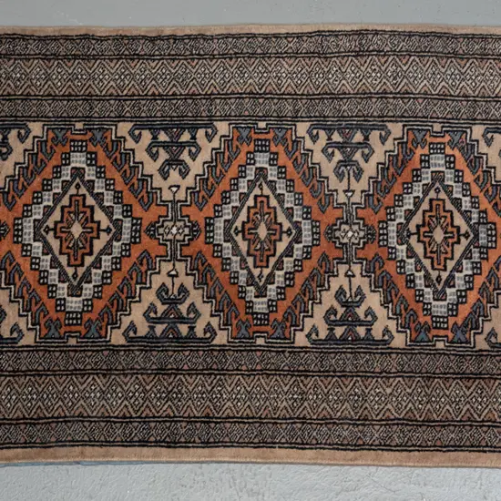 small hand knotted woolen Persian style rug, geometric motifs, black, blue & brown colours H100 W630