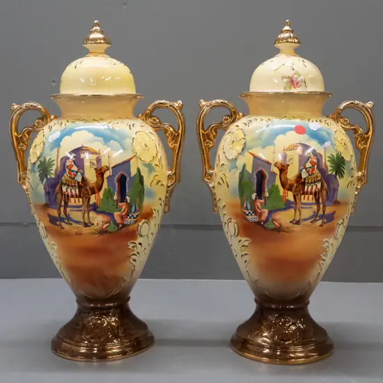 pair of Falconware lidded handled vases with Egyptian scenes & gilt decoration - repair to one finial, some wear to gilt