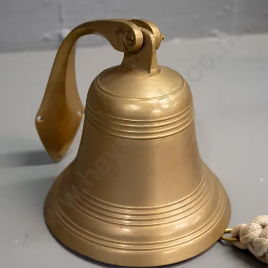 cast brass bell on swiveling wall bracket with plaited cord pull - bell is H-155 D-135