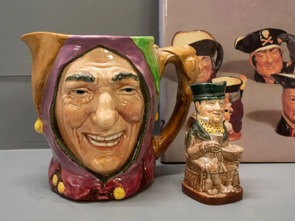 2 Royal Doulton character jugs and a book by Desmond Eyles - larger Touchstone H- 155 and smaller Mr. Micawber H-110 Image 1++