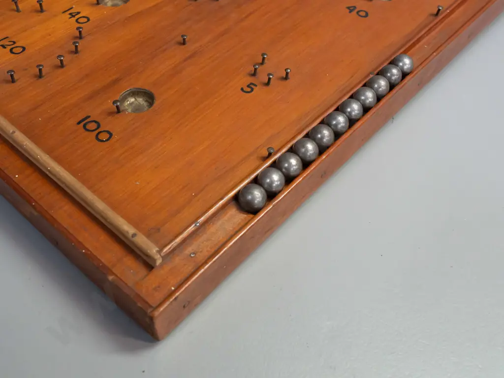 vintage NZ home made rimu bagatelle game board with 11 steel ball bearings in storage cutout inside leg Image 1++