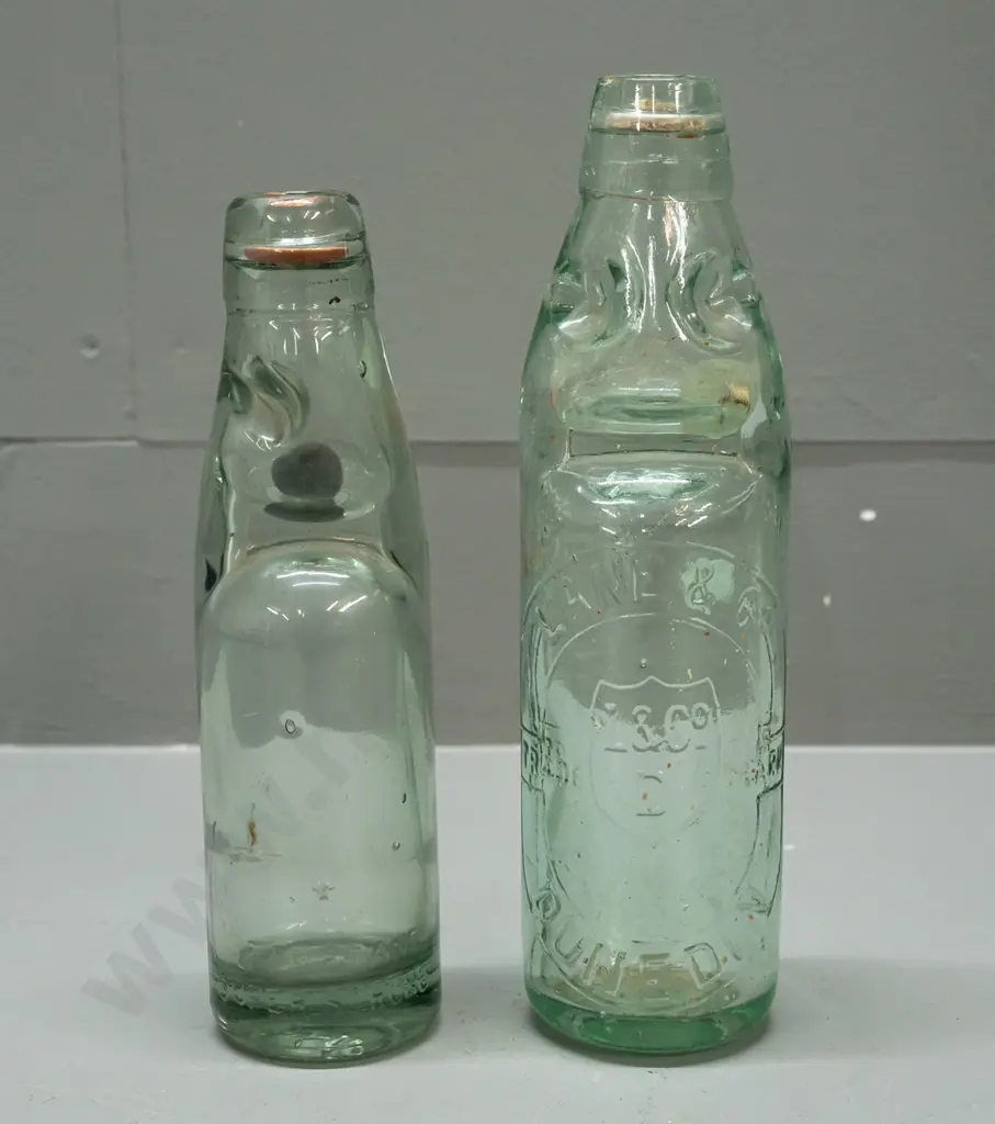 2 codd marble bottles - Lane & Co Dunedin with clear marble, a few chips, and smaller one with black or dark green Image 1++
