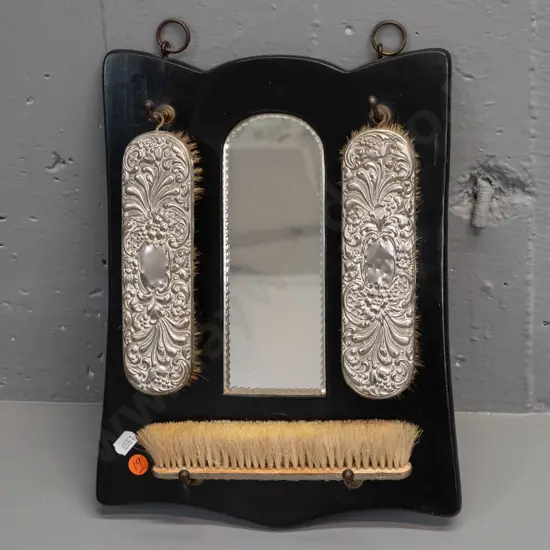 vintage wall hanging brush set with arch shaped mirror, 3 brushes with plated backing, some dents. H-320 W-220