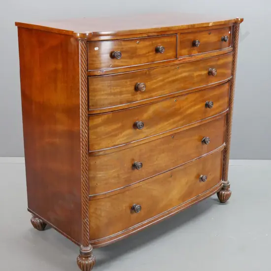 antique regency bow front 6-drawer chest with twist columns, turned wooden knobs, on fluted melon-shaped feet. Some