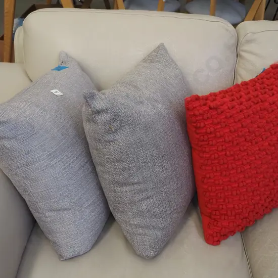 2x grey cushions, 1x red cushion
