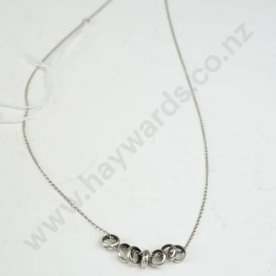 Thin silver necklace with 7 small rings