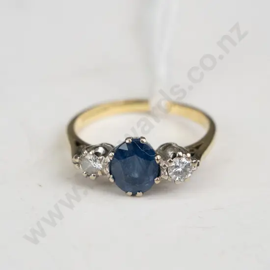 18 ct Gold ring with a sapphire in the middle and diamonds either side.