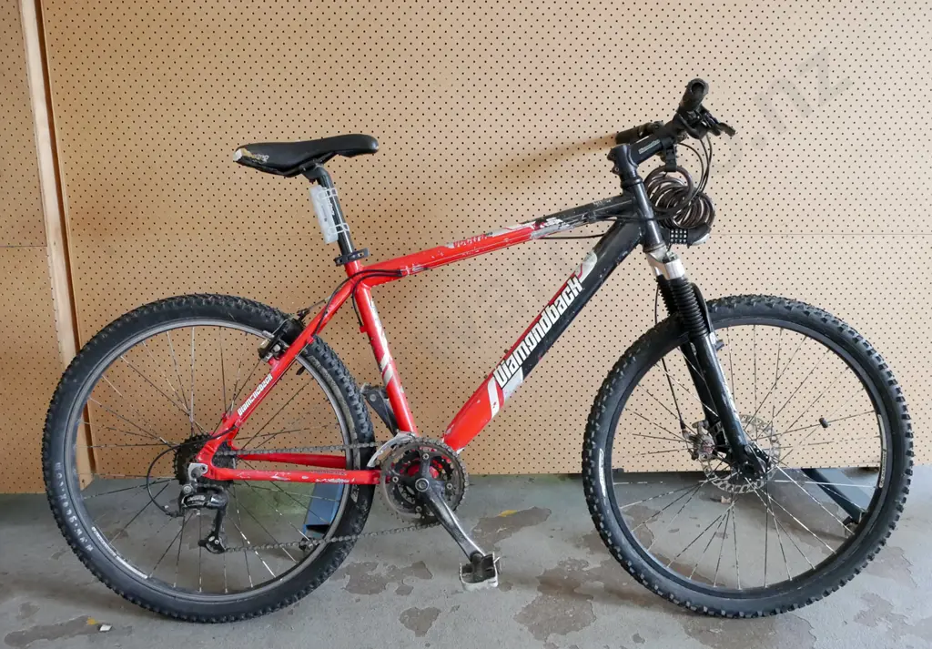 Red and Black Diamondback Bike. Has bike lock and rip in bike seat. Image 1++