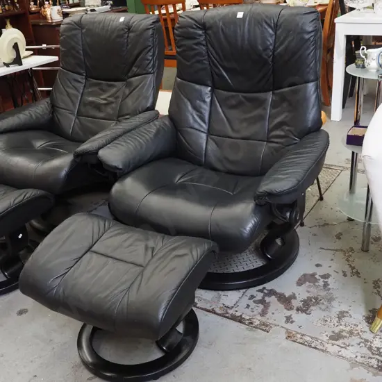 black vinyl Stressless swivel reclining armchair with matching footstool