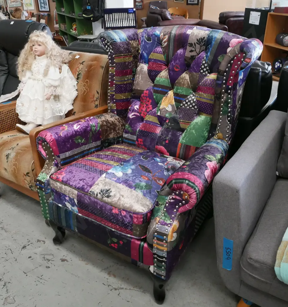 brightly patchwork style upholstered wingback armchair with cab legs and silver dome finish Image 1++