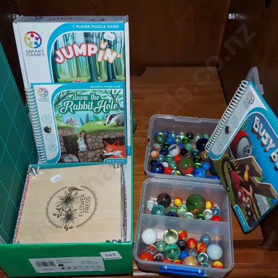shelf; marbles, flower press, Smart Games puzzles, cutting mat