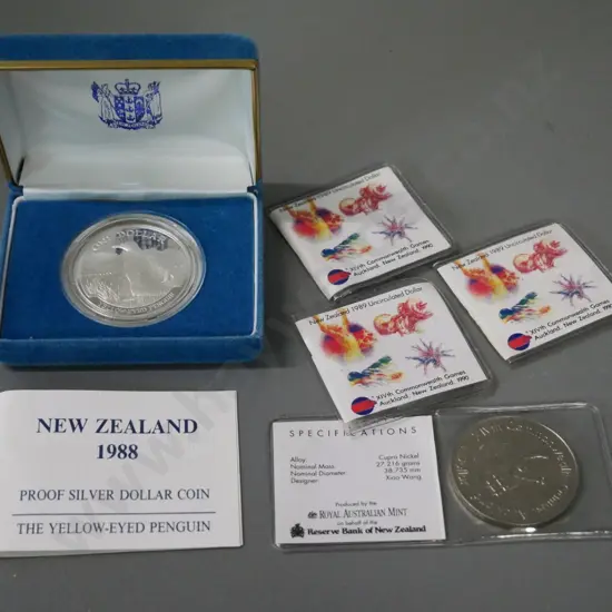 5 New Zealand coins - cased 1988 Yellow Eyed Penguin silver dollar and 4 1989 Commonwealth Games dollars in plastic