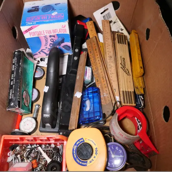 box of wooden rulers, staplers, tape measure, etc.