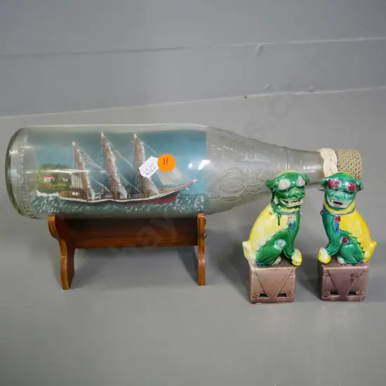 ship in a bottle on wooden stand L-300 and a small pair of porcelain foo dogs