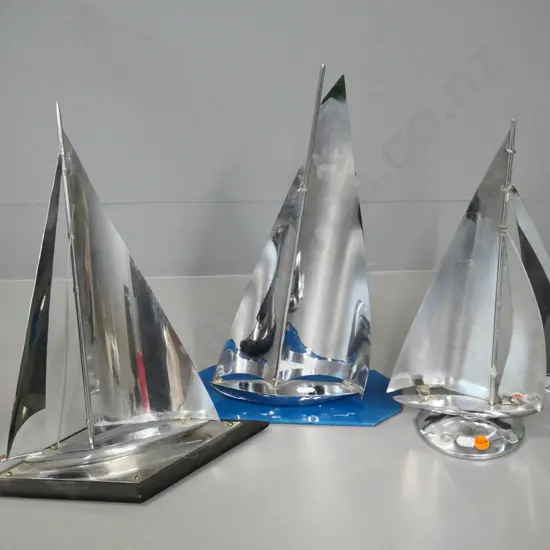 3 chrome yachts - one on glass base H-360, one on wooden base, slight discolouration or pitting, one has minor repair