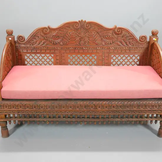 ornately carved teak settee with seat squab and loose cushions H-900 W-1470 D-640