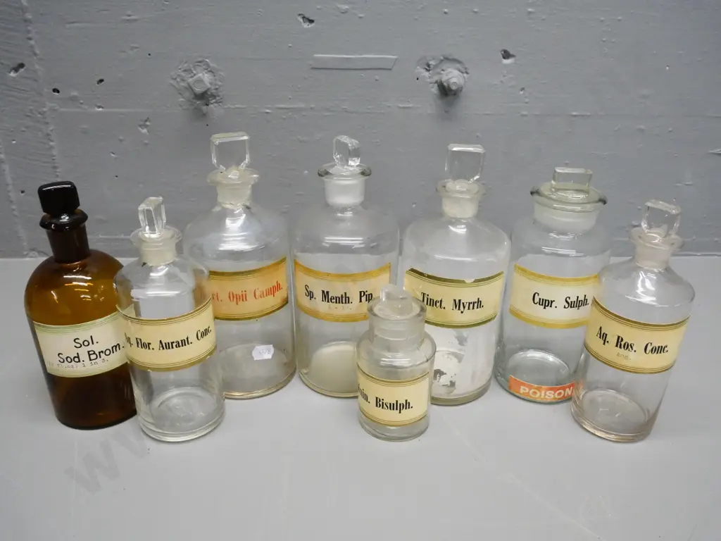 7 clear and 1 brown glass stoppered apothecary bottles with labels - tallest is H-200 Image 1++