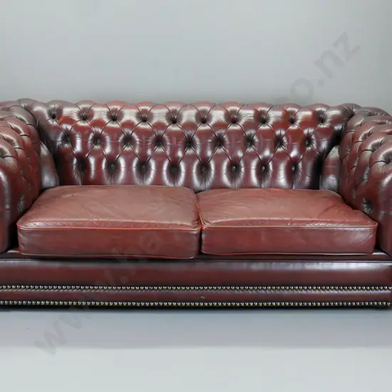 Moran of Melbourne club style rolled arm deep-button burgundy leather 2.5 seater, brass studs, casters H700 W1840 D900