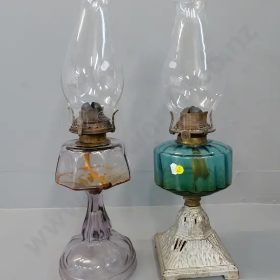 2 vintage kerosene lamps - 1 clear lavender glass and 1 teal glass on metal base, both with chimneys