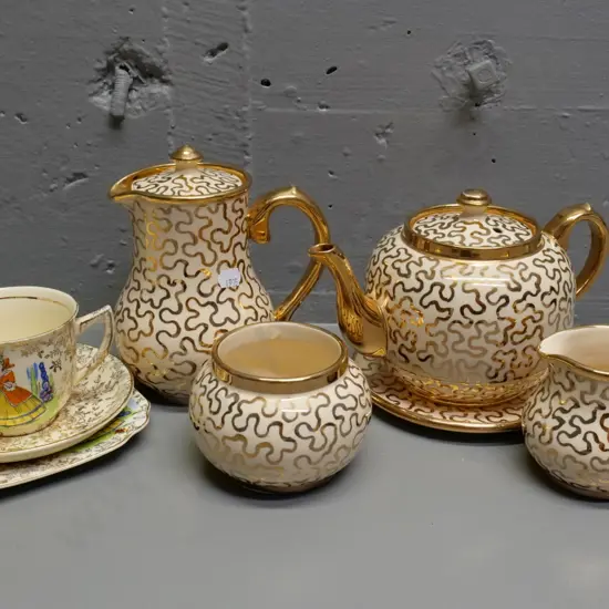 Suglow gold and cream 4-piece tea set with pot stand and an Empire crinoline lady trio