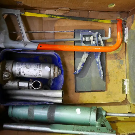 box; grease gun, bottle jack, sharpening stones etc