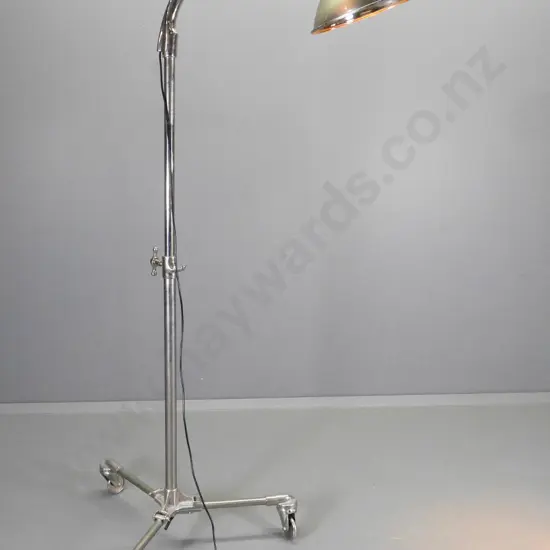 industrial style floor lamp on heavy metal casters with tilting head, some pitting to metal H1420 W1000