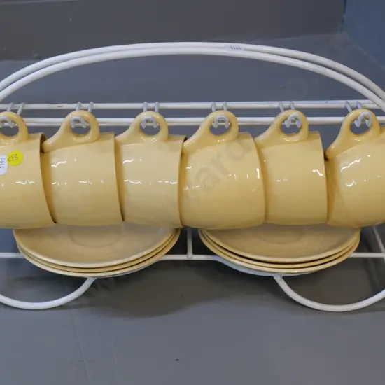 6 early Crown Lynn cups & saucers - saucers lighter colour than cups - and coated wire rack