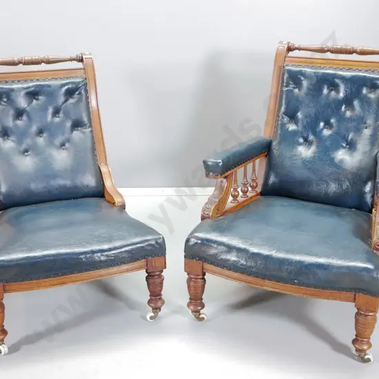 pair Edwardian carved oak w/studded dark blue lounge chairs with spindles - some cracking to vinyl H950 W700 D830